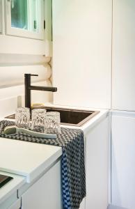 una cocina con fregadero y gafas en una encimera en HAUS ZWEINEUN en Brodersby