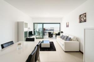sala de estar blanca con mesa y sofá en Marina Village Apartment, en Lagos