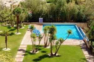 una piscina con palmeras en un jardín en Marina Village Apartment, en Lagos