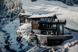 a house in the snow with snow on it at ONKL XONNA Premium Alpin Chalets in Hüttschlag