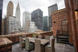 a balcony with a table and chairs and a city skyline at Tuscany by LuxUrban in New York