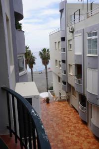 d'un balcon avec une chaise et une vue sur la plage. dans l'établissement Apartamento del Mar - Fewo am Meer Algarrobo Costa, à Algarrobo-Costa
