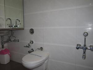 ein Badezimmer mit Toilette und zwei Wasserhähnen in der Unterkunft Hotel Sarita in Surat