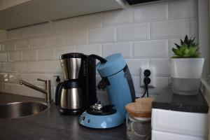 a blue mixer sitting on a counter in a kitchen at ZeeBedStay in Noordwijk aan Zee +37 photos