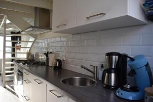 a kitchen counter with a sink and a mixer at ZeeBedStay in Noordwijk aan Zee