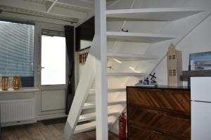 a white staircase in a room with a window at ZeeBedStay in Noordwijk aan Zee