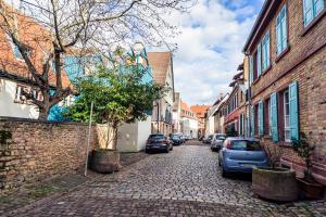 una calle adoquinada con coches y edificios aparcados en Lit Living: Luxury - Box Spring - Zwischen MA und HD - Netflix - 8 Personen, en Ladenburg