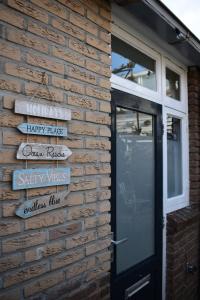 a brick wall with signs next to a door at ZeeBedStay in Noordwijk aan Zee