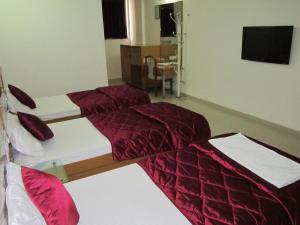 1 Schlafzimmer mit 2 Betten mit roter Decke in der Unterkunft Hotel Sarita in Surat + 33 Fotos