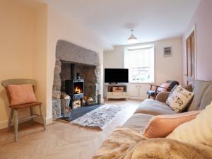 a living room with a couch and a fireplace at Bodlondeb in Porthmadog