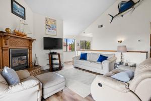 a living room with white furniture and a fireplace at Golden Sand Retreat in Cayucos