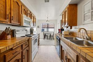 a kitchen with wooden cabinets and white appliances at Golden Sand Retreat in Cayucos
