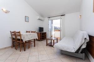 a living room with a table and chairs and a window at Apartments Crnekovic I Zarok in Ba&scaron;ka
