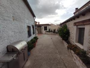 un callejón entre dos edificios con un aparato en el costado en El Cortijo del Piron, en Losana de Pirón