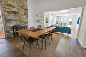 a dining room with a table and a fireplace at Cearc House in Bairnsdale