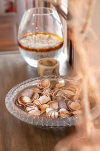 a plate of shells on a table next to a glass bowl at Hotel Cleopatra in Chorefto