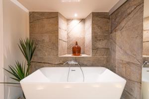 een badkamer met een wit bad en een wastafel bij Loft au bèu mitan - 50m2 in Grasse
