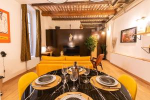a dining room with a table and yellow chairs at Loft au bèu mitan - 50m2 in Grasse