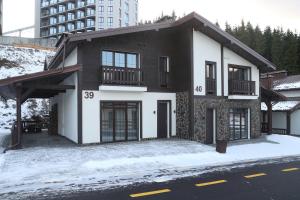 a white and black house on a snowy street at Mountain Residence 4* in Bukovel