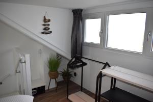 a living room with a staircase and a window at ZeeBedStay in Noordwijk aan Zee