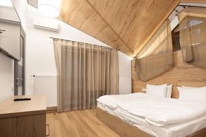 a bedroom with a bed with a wooden ceiling at Mountain Residence 4* in Bukovel