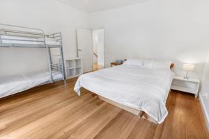 a bedroom with two bunk beds and a wooden floor at Flounder in Lake Tyers