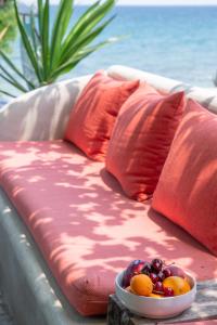 a bench with red pillows and a bowl of fruit on it at Hotel Cleopatra in Chorefto +251 photos