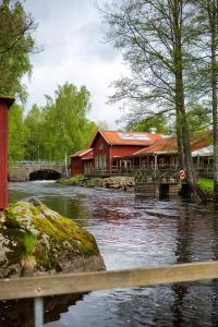 a river with a red building next to a house at STF Korrö B&B in Linneryd