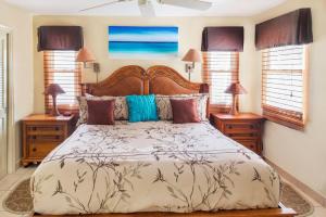 een slaapkamer met een groot bed en 2 nachtkastjes bij Coral Gardens on Grace Bay in Grace Bay