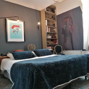 a bedroom with a bed with a blue comforter at The Appart 90m2 au coeur de la vieille ville in La Rochelle