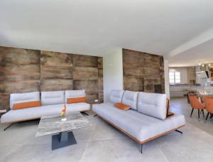 una sala de estar con 2 sofás blancos y una mesa. en Mas de Ceoulet - Villa de Luxe en Camargue, en Arles