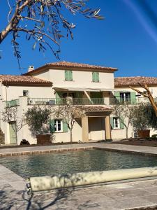 a house with a swimming pool in front of it at APICULTEUR in Oletta