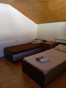 a room with two beds and a wooden ceiling at Vila Natalija in Podgorica