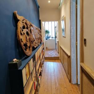 a hallway with bookshelves and a blue wall at The Appart 90m2 au coeur de la vieille ville in La Rochelle