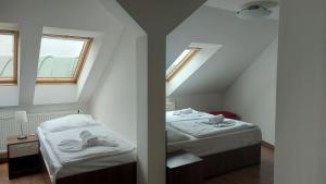 Cette chambre mansardée comprend 2 lits et un miroir. dans l'établissement Residence Vysta, à Prague