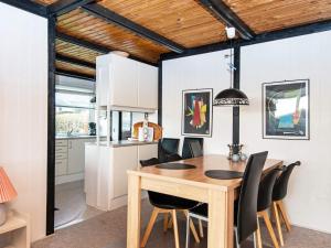 uma cozinha e sala de jantar com uma mesa de madeira e cadeiras em Holiday home Rønde XXVI em Rønde