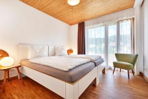ein Schlafzimmer mit einem Bett und einem großen Fenster in der Unterkunft Haus Arberblick Früchtl in Bodenmais