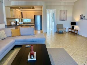 a living room with a couch and a kitchen at Hector Apartment Airport by Airstay in Spata