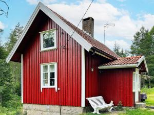 ein rotes Haus mit einer Bank davor in der Unterkunft Holiday home HALDEN II in Halden