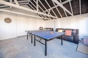a ping pong table in a room with couches at The White House Southwold in Southwold