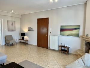 a living room with a fireplace and a wooden door at Hector Apartment Airport by Airstay in Spata