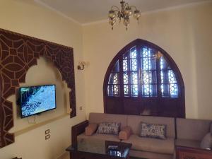 Tunisia Castle Motel في الفيوم: غرفة معيشة مع أريكة ونافذة
