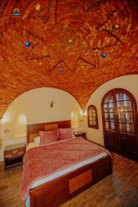 Tunisia Castle Motel في الفيوم: غرفة نوم مع سرير مع لوحة على السقف