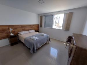 a bedroom with a bed and a window at Apartamento perfeito para descansar in Imbituba