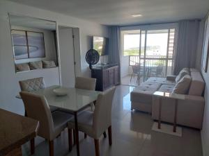 a living room with a table and a couch at Apartamento perfeito para descansar in Imbituba