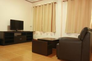 a living room with a chair and a television at ChillHouse24 @ DonMueang in Ban Don Muang (1)