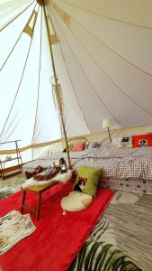 ein Schlafzimmer mit einem Bett in einem Zelt in der Unterkunft Cat A Camp - Khao Yai 