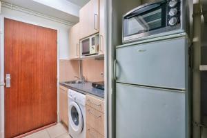 uma cozinha com um frigorífico e uma máquina de lavar e secar roupa em Cosy studio in the center of Clichy em Clichy