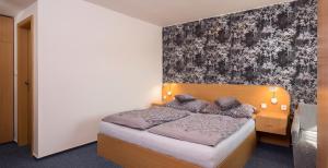 1 dormitorio con cama y pared en Hotel Kobero en Říčany u Brna