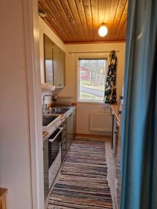 a kitchen with a rug on the floor and a window at Utsikt mot viken in Undenäs